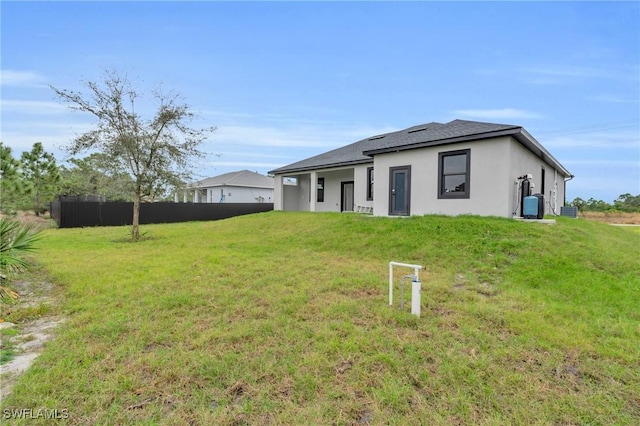 rear view of property with a lawn