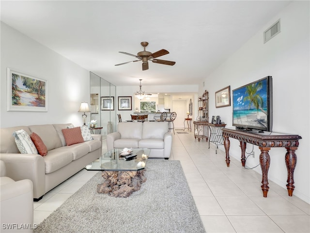 tiled living room featuring ceiling fan with notable chandelier