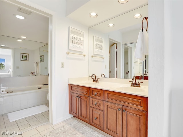 bathroom featuring vanity, toilet, tile patterned floors, and a relaxing tiled tub