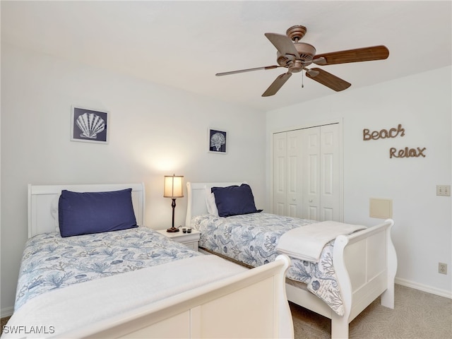 carpeted bedroom featuring ceiling fan and a closet