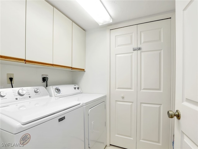 laundry area with washer and clothes dryer and cabinets