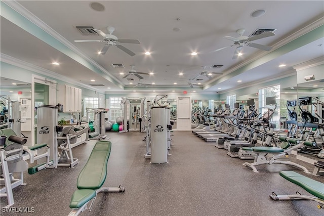 gym with crown molding, ceiling fan, and a raised ceiling