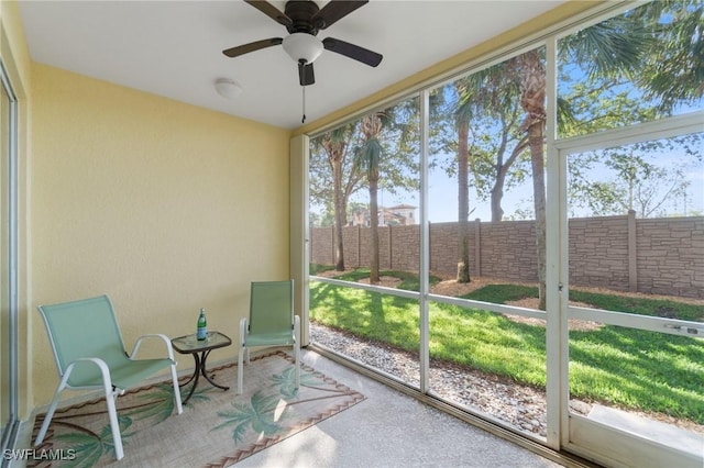 unfurnished sunroom with ceiling fan