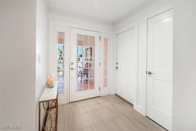 doorway with crown molding and light hardwood / wood-style flooring