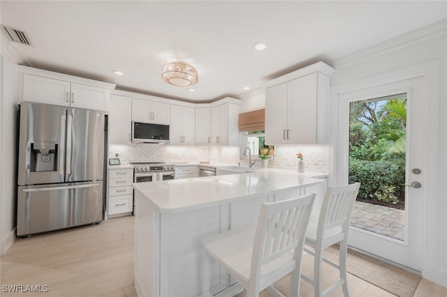 kitchen featuring backsplash, appliances with stainless steel finishes, sink, and white cabinets