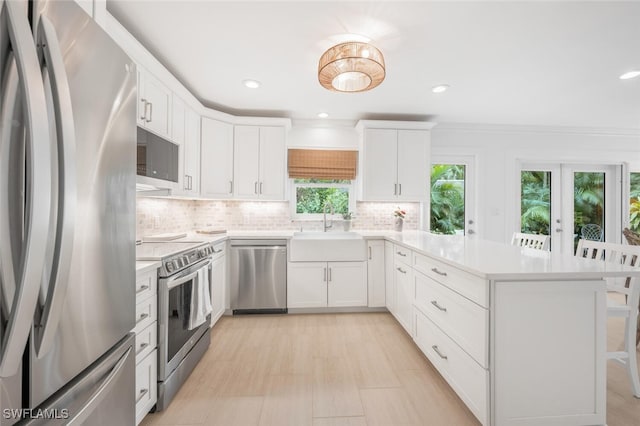 kitchen featuring sink, white cabinetry, crown molding, appliances with stainless steel finishes, and decorative backsplash