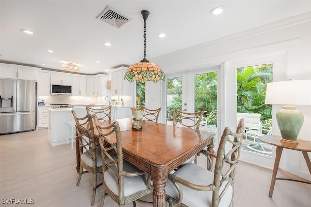 dining space featuring crown molding and french doors