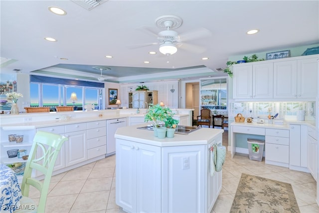 kitchen featuring white dishwasher, kitchen peninsula, white cabinets, and a kitchen island