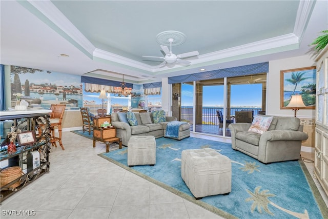 living room featuring a tray ceiling, ornamental molding, and light tile patterned flooring