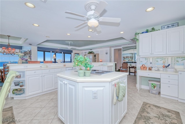 kitchen featuring white cabinetry, light tile patterned floors, a raised ceiling, kitchen peninsula, and a kitchen island