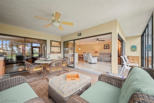 living room with ceiling fan and a textured ceiling