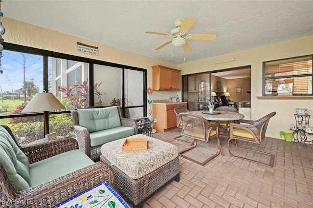 sunroom / solarium featuring ceiling fan