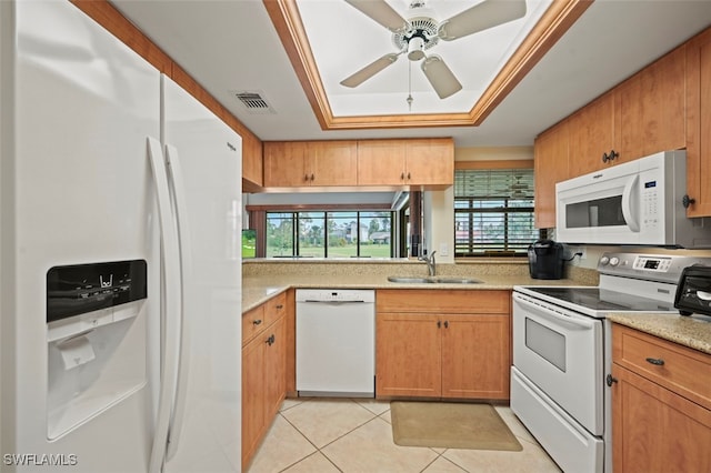 kitchen featuring ceiling fan, a raised ceiling, sink, light tile patterned floors, and white appliances