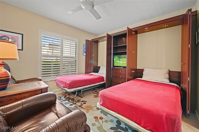 carpeted bedroom featuring ceiling fan and a textured ceiling