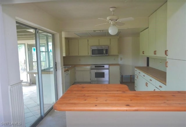 kitchen featuring butcher block counters, white dishwasher, kitchen peninsula, ceiling fan, and stove