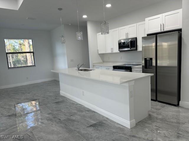 kitchen featuring white cabinetry, a kitchen island with sink, stainless steel appliances, and hanging light fixtures