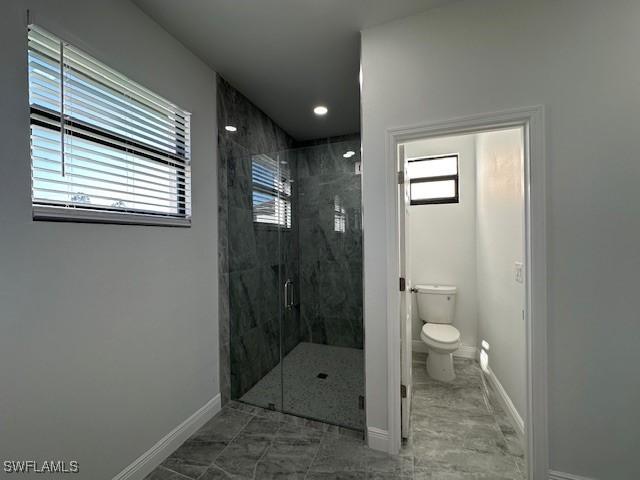 bathroom featuring an enclosed shower and toilet