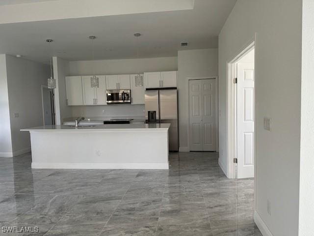 kitchen with appliances with stainless steel finishes, white cabinetry, a kitchen island with sink, and sink