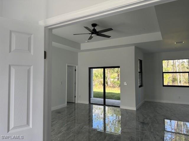 spare room featuring a tray ceiling and ceiling fan