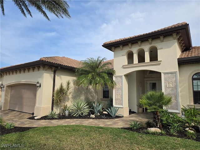 mediterranean / spanish house featuring a garage and a front yard