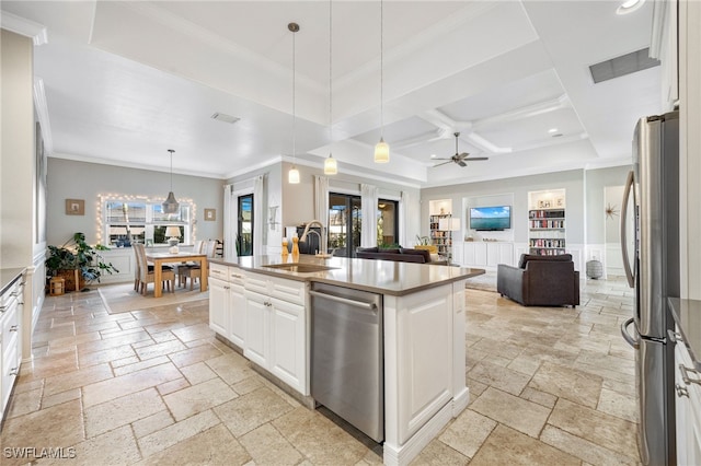 kitchen featuring pendant lighting, sink, white cabinetry, stainless steel appliances, and an island with sink