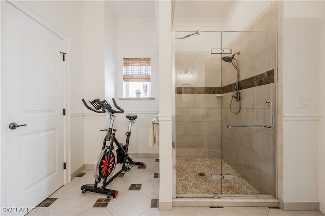 bathroom with crown molding, a shower with shower door, and tile patterned flooring