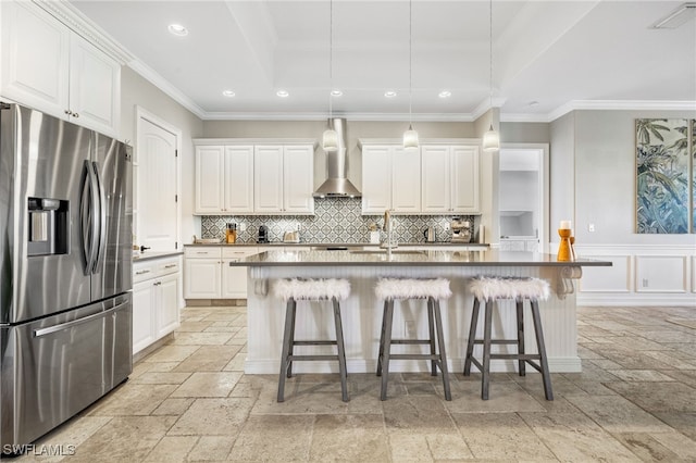 kitchen with wall chimney exhaust hood, white cabinets, and stainless steel refrigerator with ice dispenser