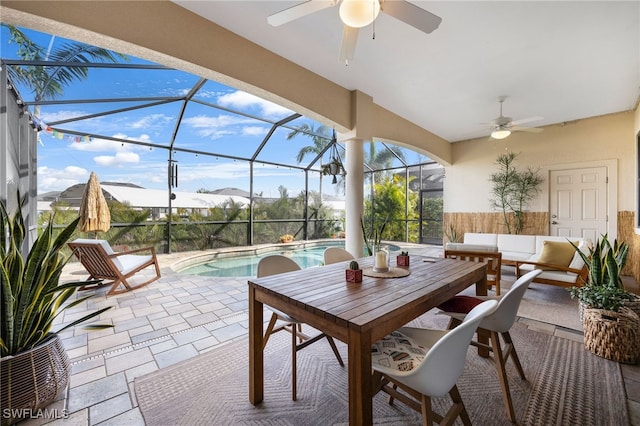 view of patio featuring ceiling fan, an outdoor living space, and glass enclosure