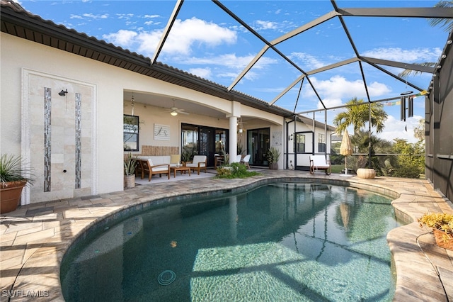 view of swimming pool with ceiling fan, outdoor lounge area, glass enclosure, and a patio area