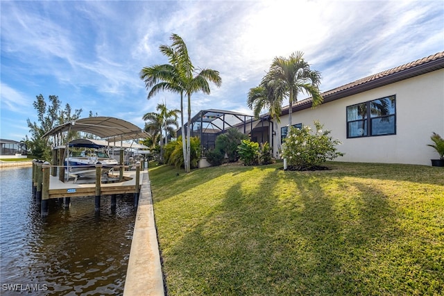 dock area with a water view, glass enclosure, and a lawn