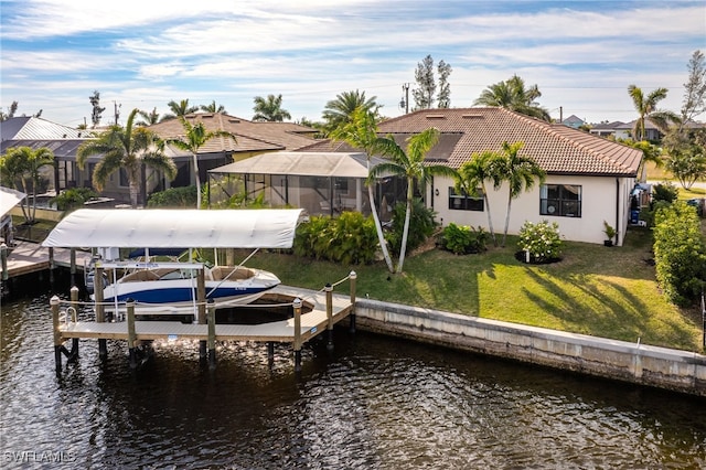 view of dock with a water view, a yard, and a lanai