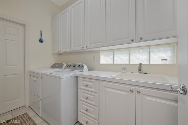 laundry area with light tile patterned flooring, cabinets, sink, and washer and dryer