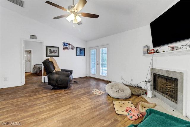 living area with vaulted ceiling, hardwood / wood-style floors, ceiling fan, and french doors