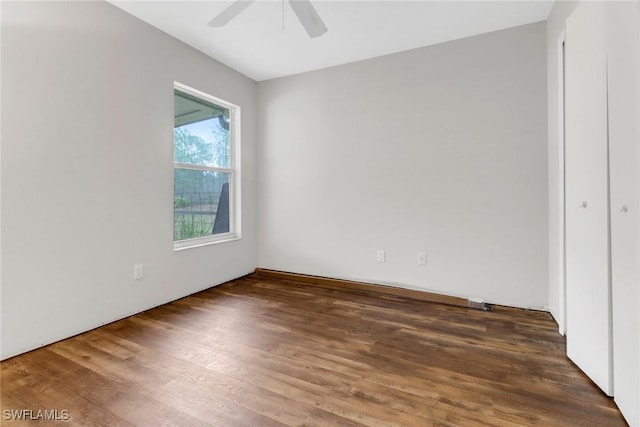 unfurnished room featuring dark wood-type flooring and ceiling fan