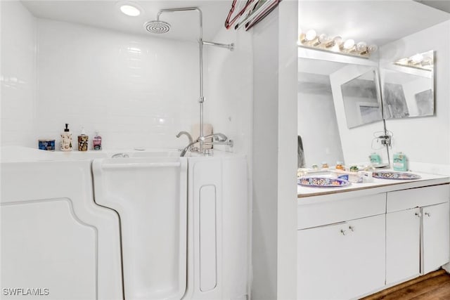 bathroom featuring vanity, hardwood / wood-style flooring, and a bathing tub