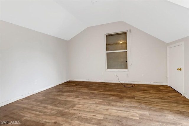 additional living space featuring wood-type flooring and vaulted ceiling