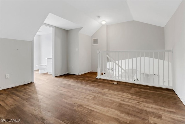 additional living space featuring hardwood / wood-style floors and vaulted ceiling