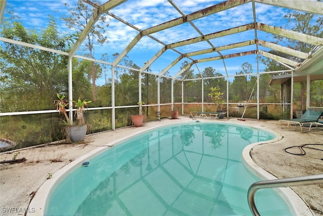 view of pool with a patio and glass enclosure