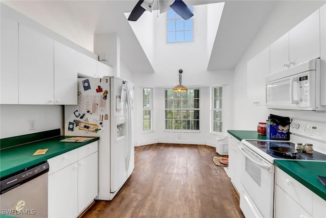 kitchen with white appliances, decorative light fixtures, ceiling fan, hardwood / wood-style floors, and white cabinets