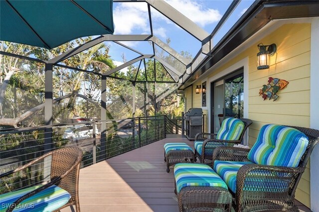 deck with glass enclosure, a grill, and outdoor lounge area