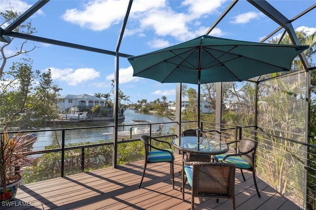 deck featuring a water view and glass enclosure