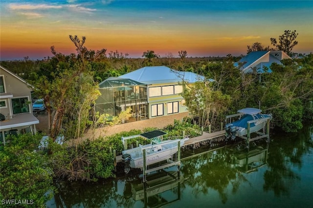 aerial view at dusk featuring a water view