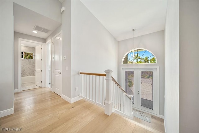 entrance foyer with french doors and light hardwood / wood-style flooring