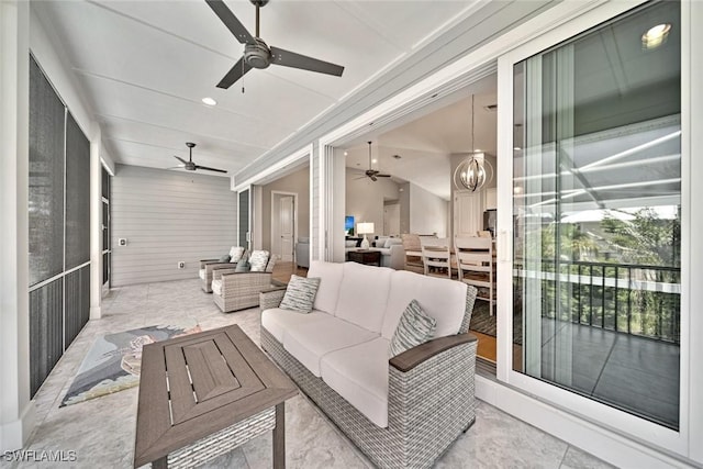 sunroom / solarium featuring ceiling fan with notable chandelier