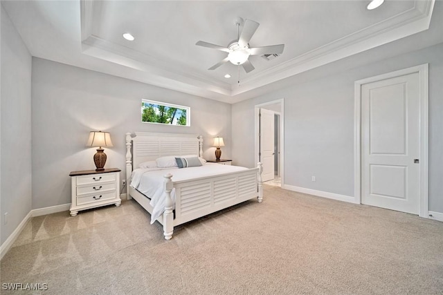 bedroom featuring ceiling fan, ornamental molding, light colored carpet, and a tray ceiling