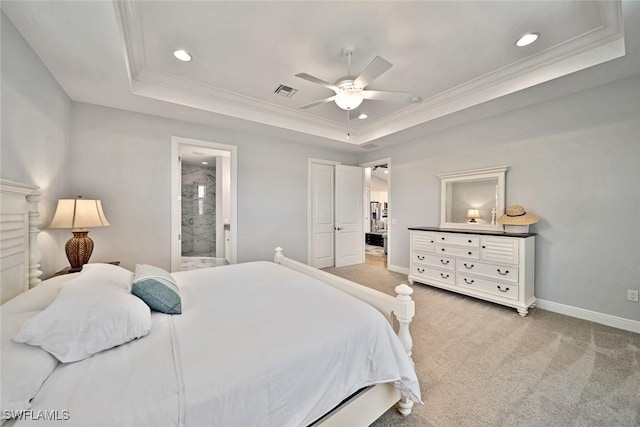 carpeted bedroom with ceiling fan, crown molding, a tray ceiling, and ensuite bathroom