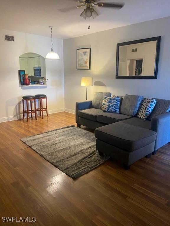 living room with hardwood / wood-style flooring and ceiling fan