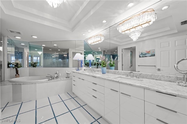 bathroom with plus walk in shower, a notable chandelier, a tray ceiling, and vanity