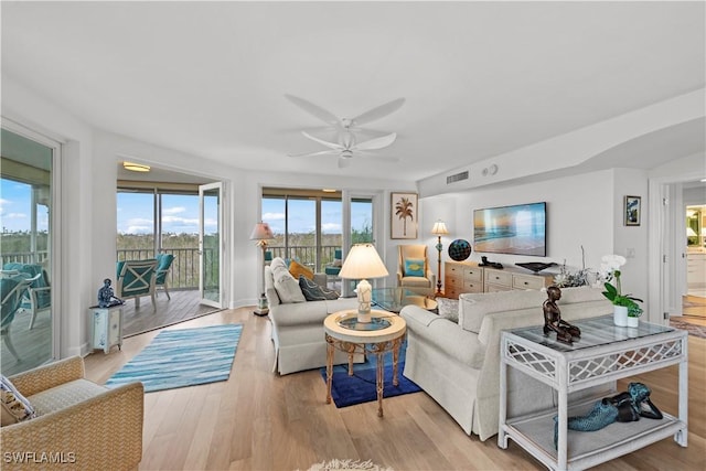 living room featuring light hardwood / wood-style flooring and ceiling fan