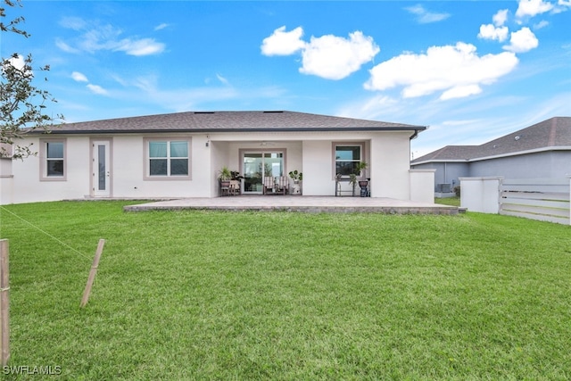 back of house featuring a lawn and a patio area